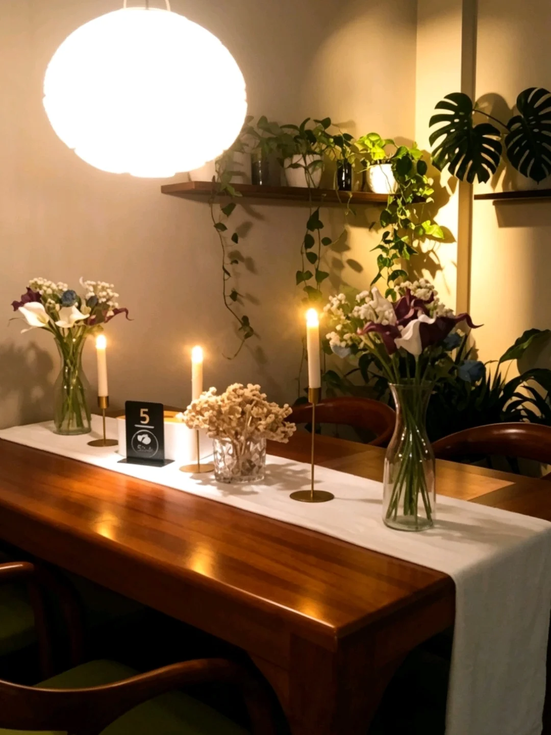Meja elegan dengan lilin dan bunga di 5oUs Steakhouse